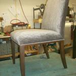 Custom built and upholstered dining room chair with walnut legs and coil spring construction.
